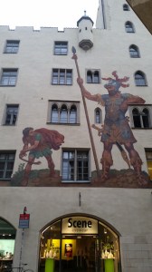 an old-fashioned mural of David and Goliath atop a modern eyewear store